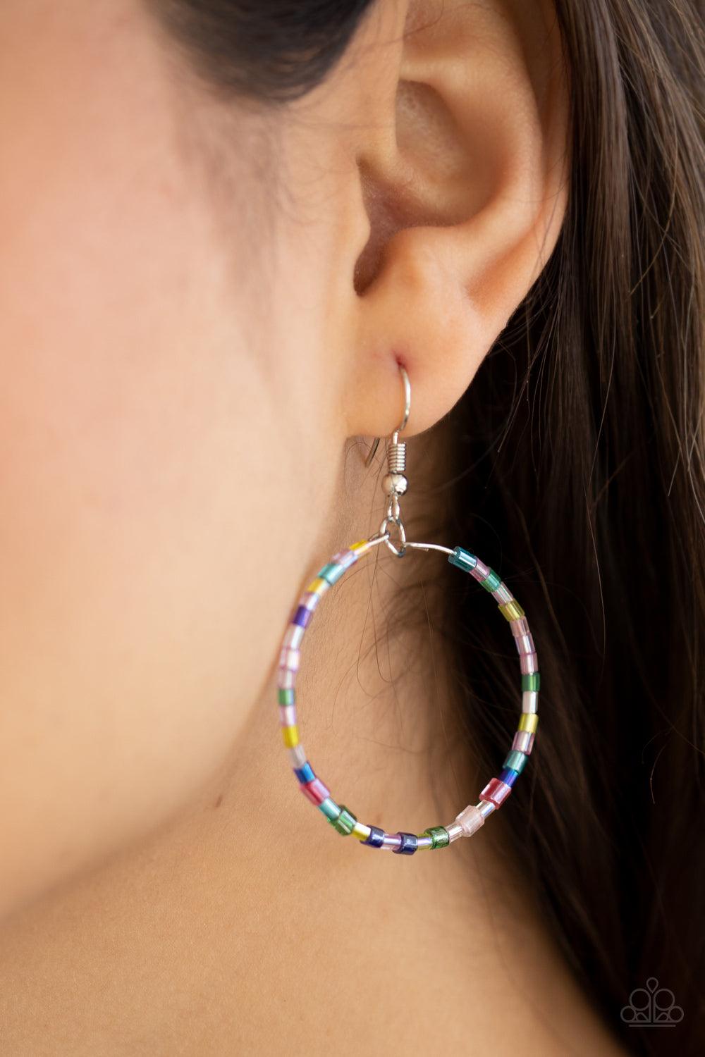 Paparazzi Accessories Colorfully Curvy - Multi Featuring an iridescent shimmer, glassy multicolored seed beads are threaded along a dainty wire hoop for a colorful finish. Earring attaches to a standard fishhook fitting. Sold as one pair of earrings. Jewe