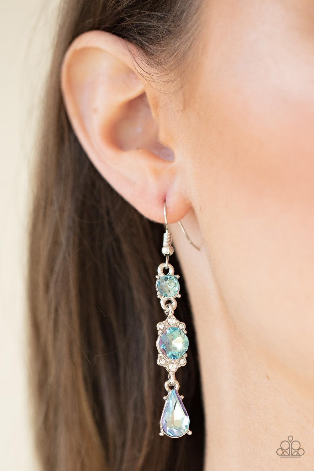 Paparazzi Accessories Outstanding Opulence - Blue Featuring a white rhinestone encrusted frame, an oversized blue rhinestone is linked between a classic round and teardrop blue rhinestone for an elegantly stacked look. Earring attaches to a standard fishh