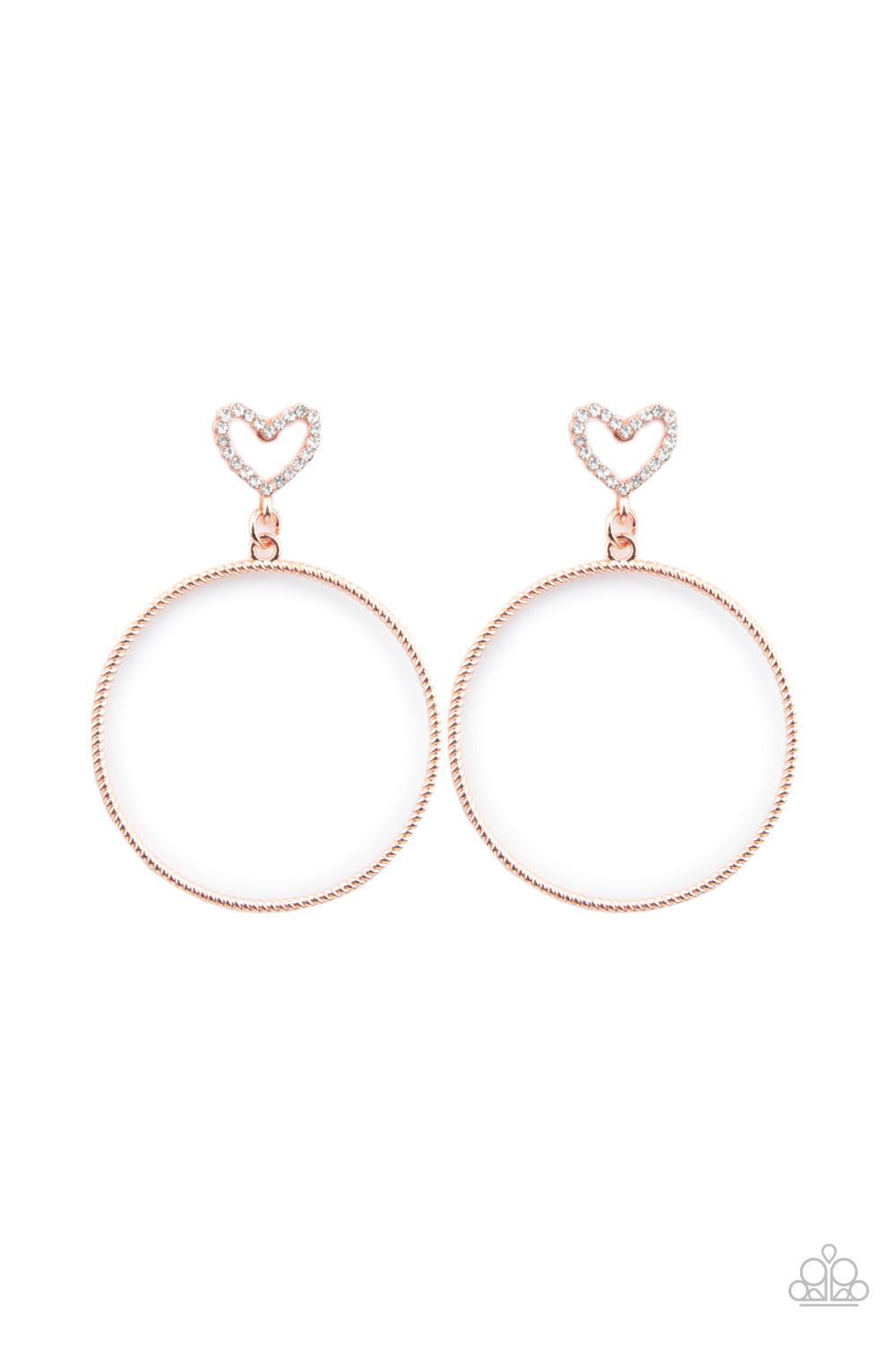 Paparazzi Accessories Love Your Curves - Copper A twisted shiny copper hoop swings from the bottom of a white rhinestone encrusted heart frame, creating a flirtatious statement piece. Earring attaches to a standard post fitting. Sold as one pair of post e