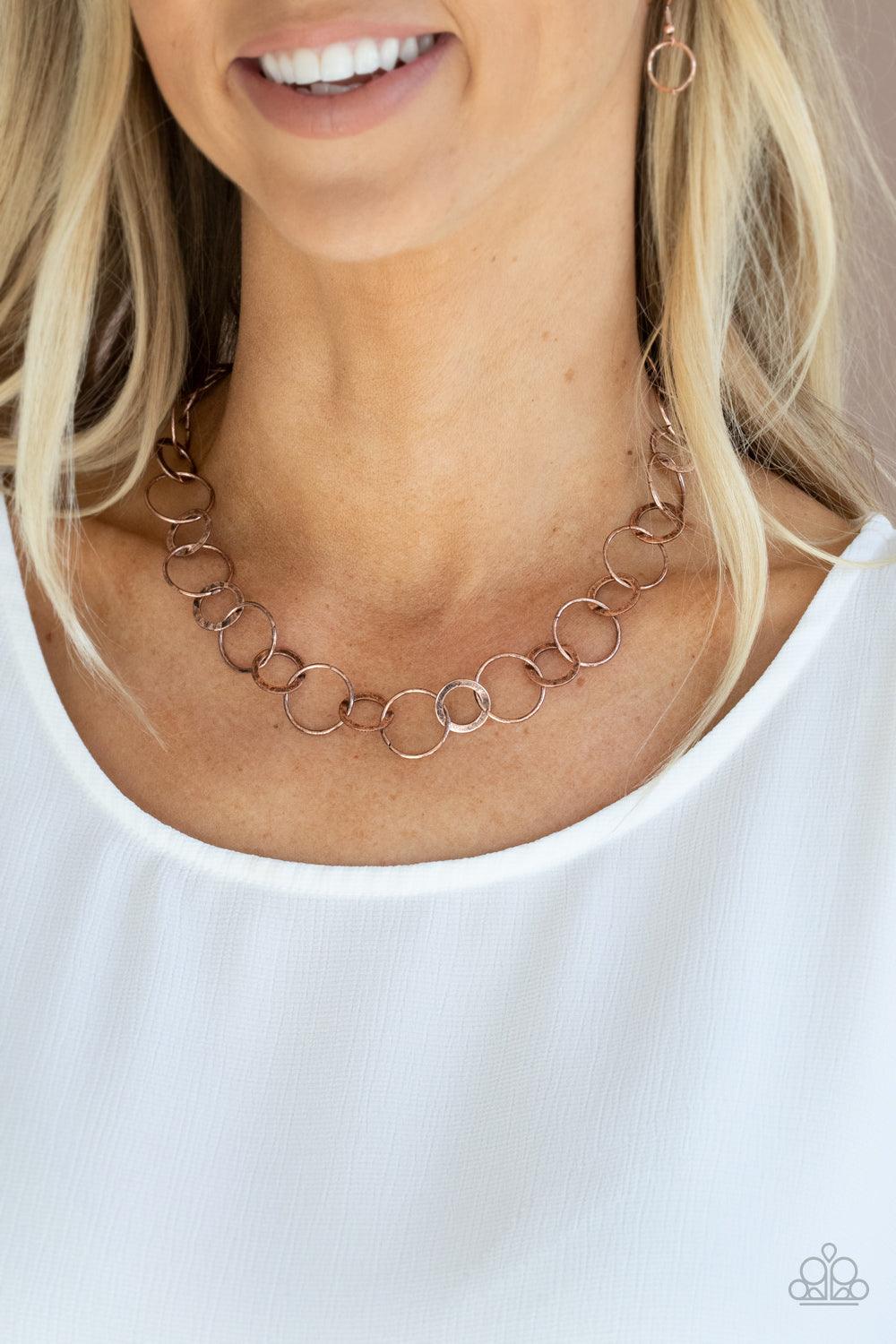 Paparazzi Accessories Revolutionary Radiance - Copper Dainty copper hoops and rustic rings delicately link into a chic chain, creating simplistic shimmer below the collar. Features an adjustable clasp closure. Sold as one individual necklace. Includes one