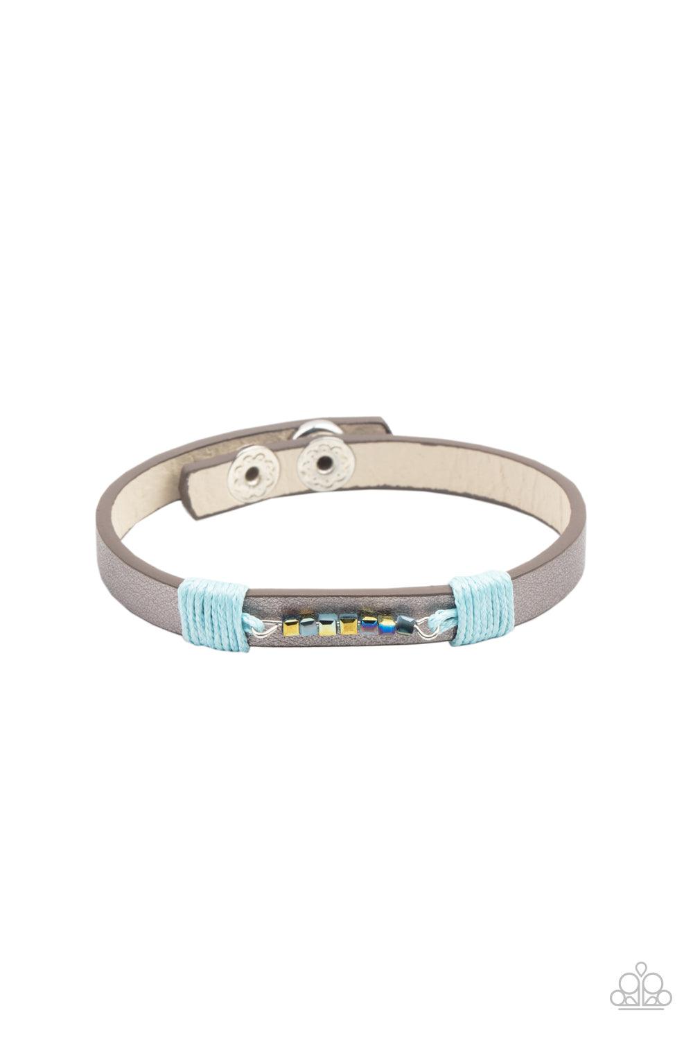 Paparazzi Accessories Worth The Hype - Blue Threaded along a dainty rod, a row of metallic and iridescent blue cube beads are knotted in place across the center of a silvery leather band. Features an adjustable snap closure. Sold as one individual bracele