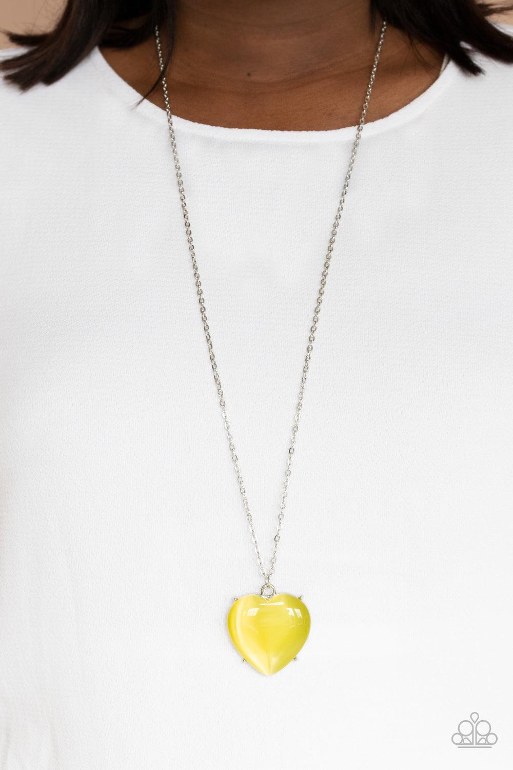 Paparazzi Accessories Warmhearted Glow - Yellow An oversized Illuminating cat's eye stone frame swings from the bottom of a lengthened silver chain, creating a flirtatious pendant. Features an adjustable clasp closure. Sold as one individual necklace. Inc