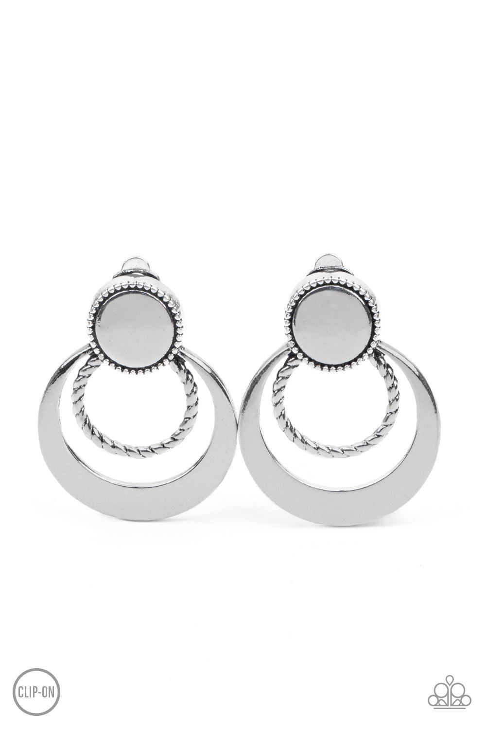 Paparazzi Accessories Refined Ruffles - Silver **Clip-On A twisted silver ring and crescent shaped silver frame ripple out from the bottom of a textured silver disc, creating a refined lure. Earring attaches to a standard clip-on fitting. Sold as one pair