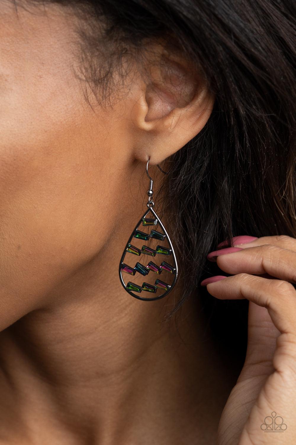 Paparazzi Accessories Glitzy Grit - Multi Flared emerald cut oil spill rhinestones haphazardly stack in rows across the center of an airy gunmetal teardrop, creating an edgy frame. Earring attaches to a standard fishhook fitting. Sold as one pair of earri
