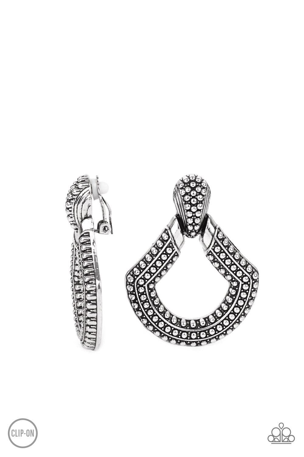 Paparazzi Accessories Better Buckle Up - Silver *Clip-On Dotted in rows of studded details, an oversized silver buckle-like frame adorns the ear for a rustic fashion. Earring attaches to a standard clip-on fitting. Sold as one pair of clip-on earrings. Je