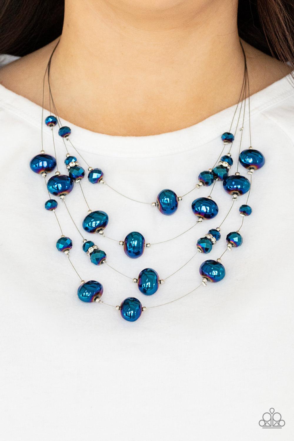 Paparazzi Accessories Cosmic Real Estate - Blue Featuring an oil spill finish, metallic blue beads and faceted crystal-like accents are fitted in place along dainty wires, creating the illusion of floating layers below the collar. Dainty silver beads and