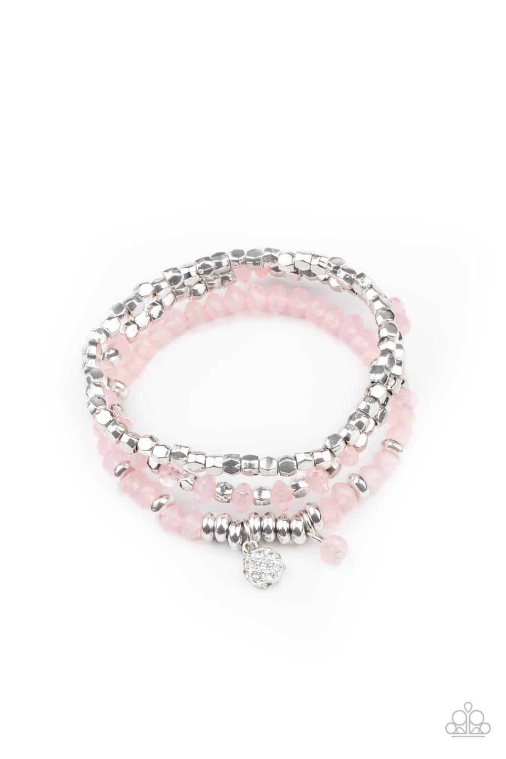 Paparazzi Accessories Glacial Glimmer - Pink A glimmering collection of silver discs, silver cube beads, and opaque pink crystal-like beads are threaded along stretchy bands around the wrist, creating icy layers. A matching opaque crystal and white rhines
