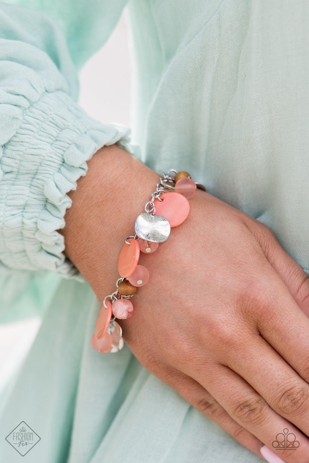 Paparazzi Accessories Springtime Springs - Orange Springtime charms of shiny and soft beads and pearl-like discs in lovely tones of Burnt Coral sway from a silver chain. Accents of sparkly, wavy silver discs and wooden beads bring it down to earth as the