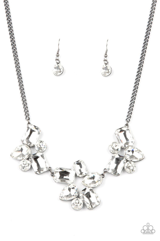 Paparazzi Accessories Galactic Goddess - Black An unexpected explosion of oversized round, teardrop, and emerald cut rhinestones cluster into haphazard groupings. The blinding clusters link together, creating a stellar statement piece that sits below the