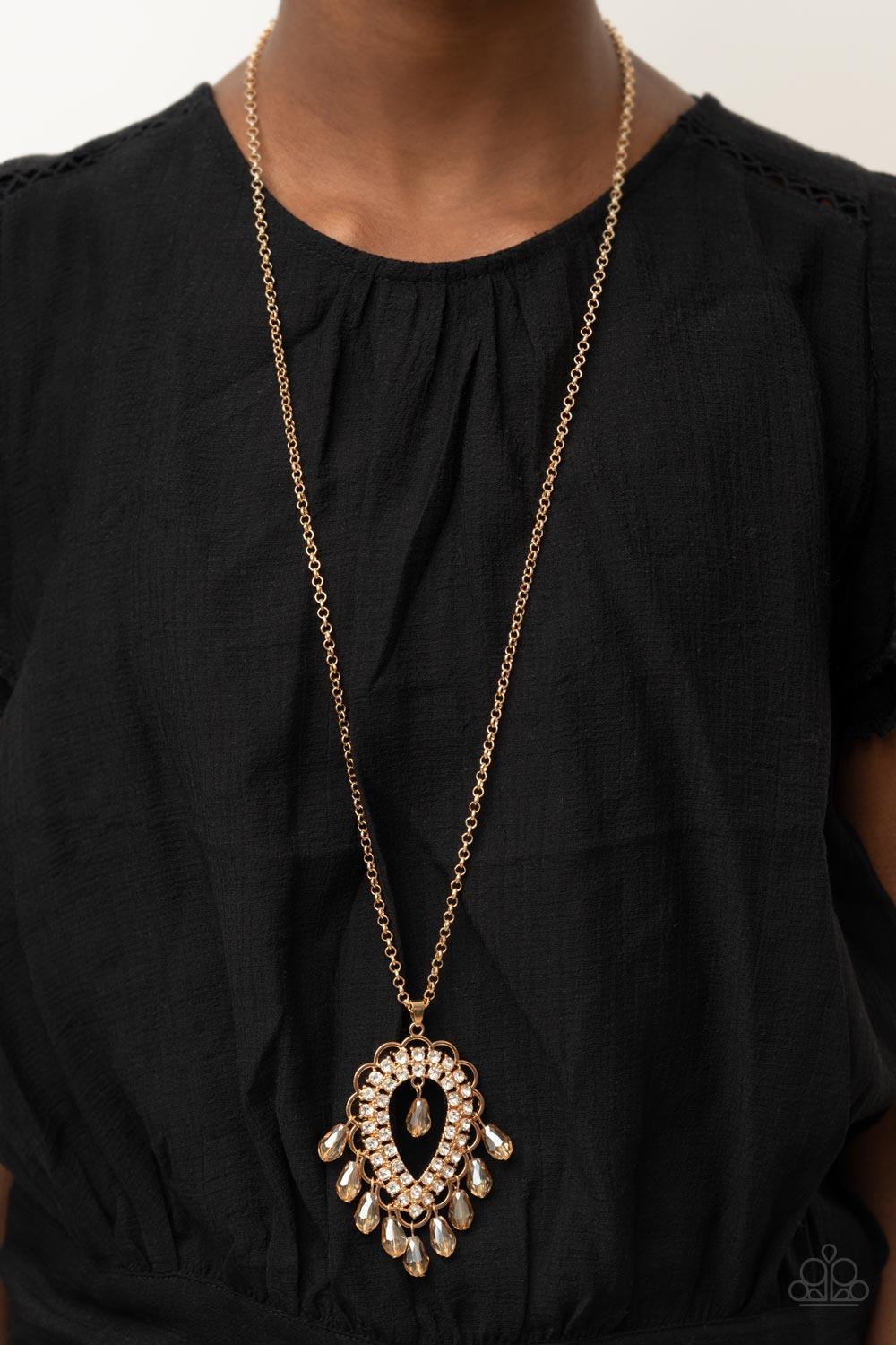 Paparazzi Accessories Teasable Teardrops - Gold An oversized scalloped teardrop frame, tipped on its point, encases rows of sparkling white rhinestones in its lustrous gold fittings. Shimmery faceted champagne teardrop beads dangle daintily from the scall