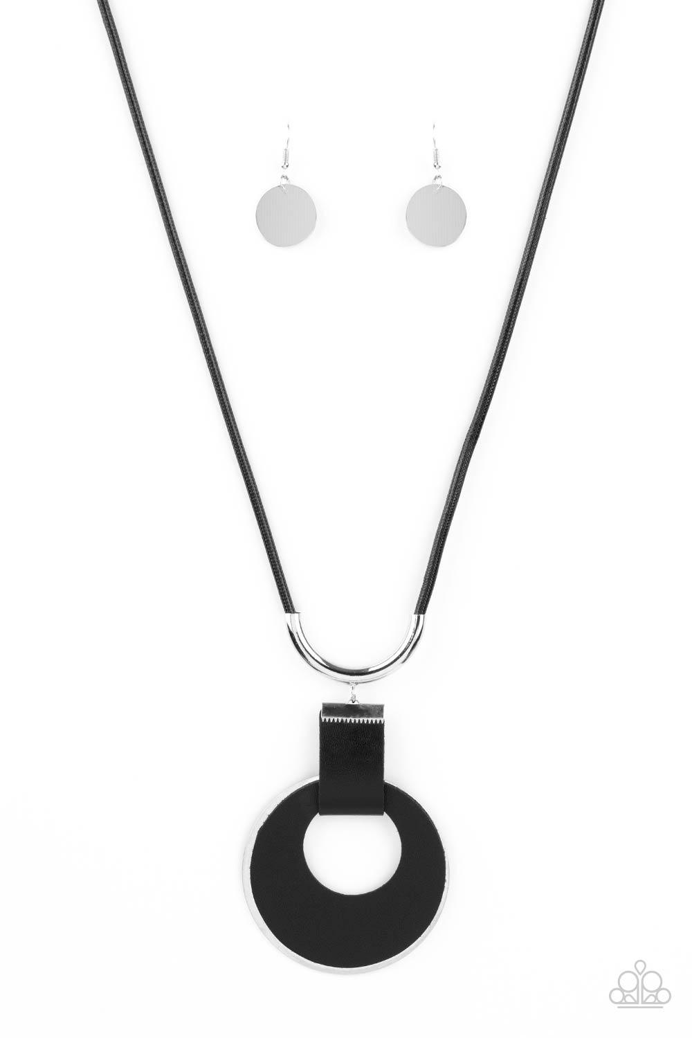 Paparazzi Accessories Luxe Crush - Black A large cutout silver disc, overlaid with black leather, is cradled in a wide black leather strap. The luxe pendant sways from a U-shaped silver cylinder threaded along the end of a lengthened polished black cord f
