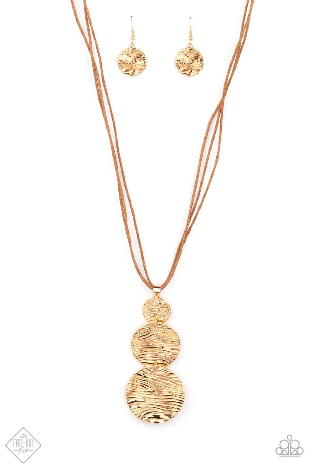 Paparazzi Accessories Circulating Shimmer - Gold Three shimmery gold discs featuring a wavy pattern flowing across the front, link together in graduating sizes at the end of a lengthened brown cord for an alluring appeal. Features an adjustable clasp clos