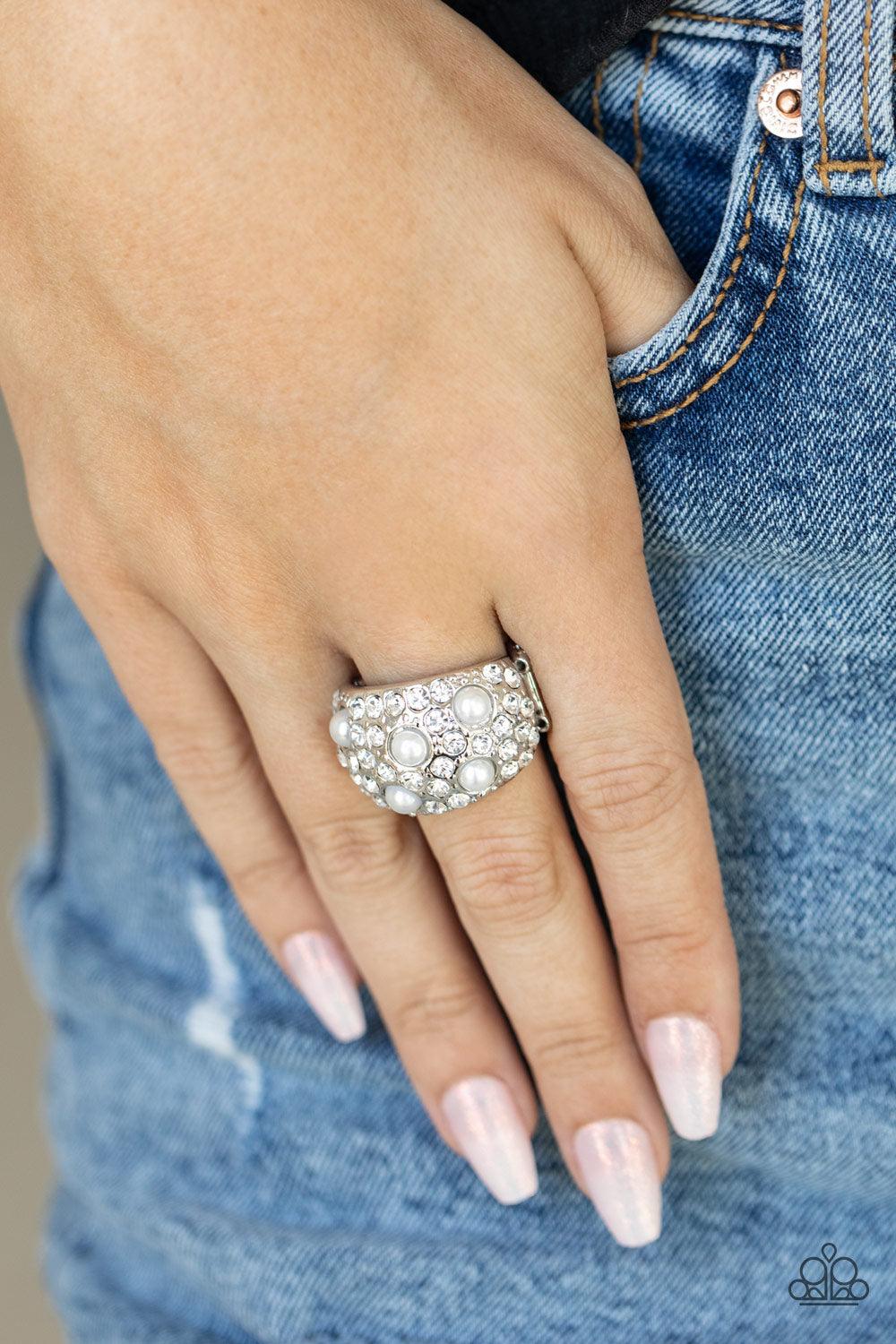 Paparazzi Accessories Gatsbys Girl - White An explosion of dainty white rhinestones and bubbly white pearls are encrusted across the front of a thick silver band, creating a glamorous centerpiece atop the finger. Features a stretchy band for a flexible fi