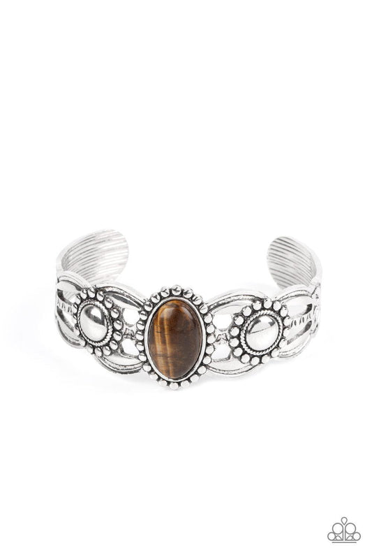 Paparazzi Accessories Solar Solstice - Brown An oval Tiger's eye stone is pressed into the center of a studded silver frame atop an airy silver cuff embellished in studded sun-like frames for an earthy pop of seasonal color around the wrist. Sold as one i
