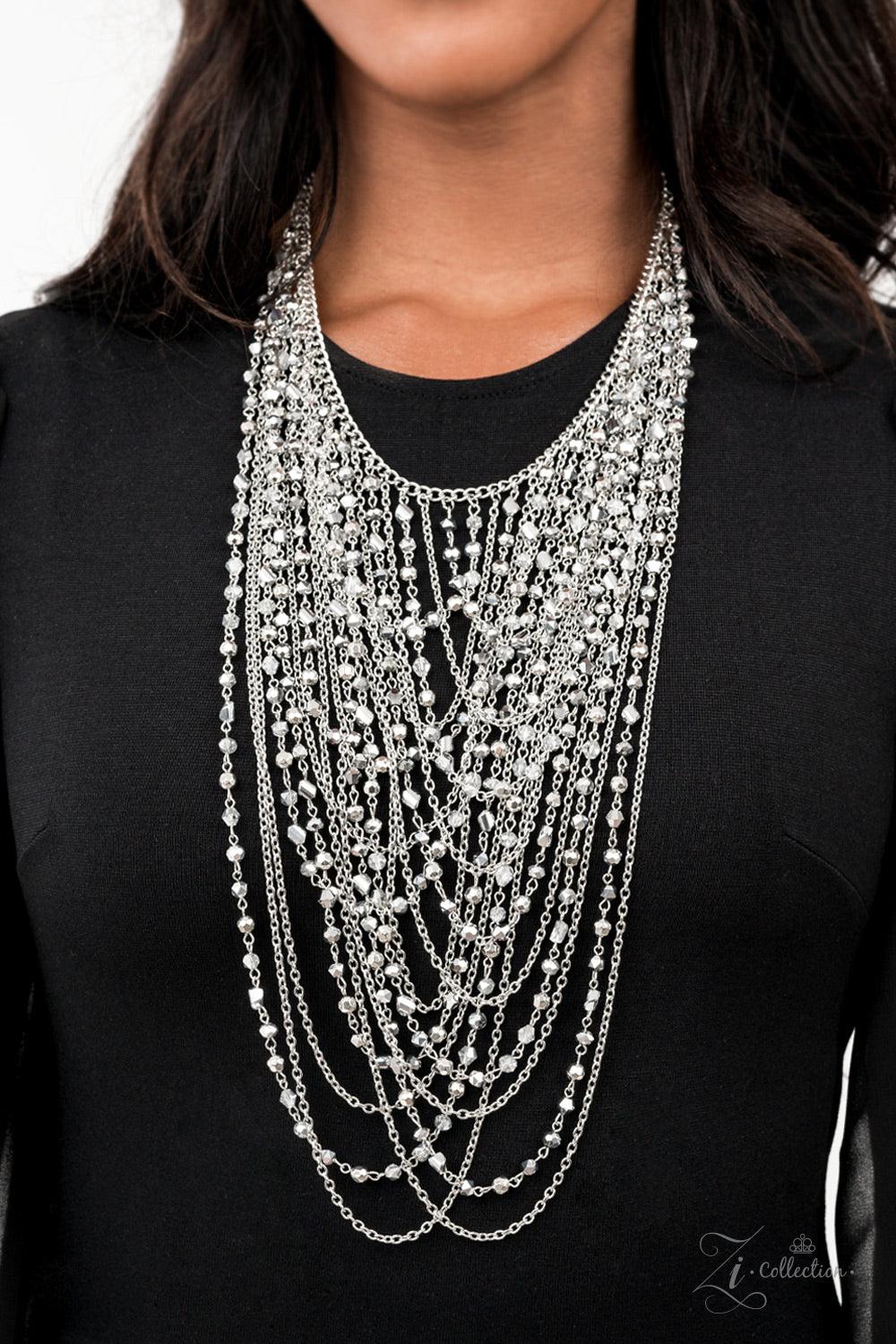 Paparazzi Accessories Enticing An entrancing collection of raw cut, faceted, and crystal-like silver and hematite beads delicately connect into glitzy strands that dauntlessly drape across the chest. Intermixed with plain silver chains, the swooping layer