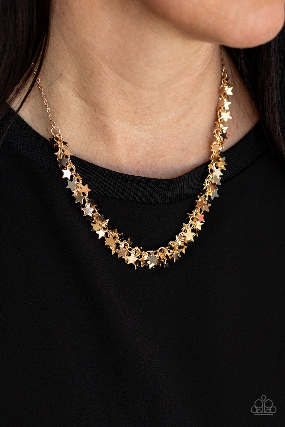 Paparazzi Accessories Starry Anthem - Gold A glistening collection of dainty gold star charms delicately cluster on a classic gold chain, creating a stellar fringe below the collar. Features an adjustable clasp closure. Sold as one individual necklace. In