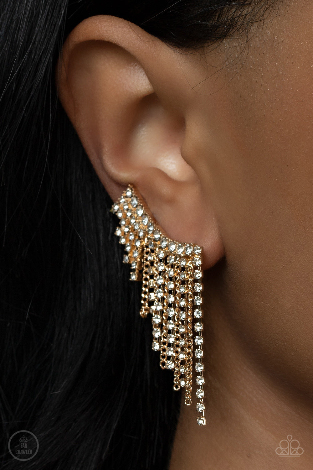 Paparazzi Accessories Thunderstruck Sparkle - Gold A tapered fringe of dainty gold chains and glittery strands of white rhinestones cascades from the edge of a curving white rhinestone encrusted frame, creating an edgy centerpiece. Features a clip-on fitt