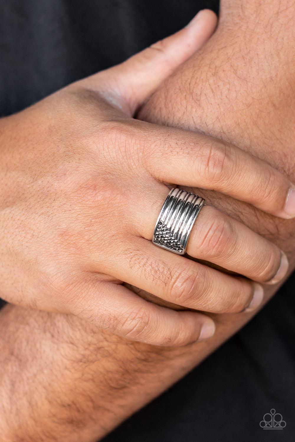 Paparazzi Accessories Legendary Lineup - Silver Engraved in linear patterns, the corner of a thick silver band has been chiseled away and encrusted in dainty rows of hematite rhinestones for a standout finish. Features a stretchy band for a flexible fit.