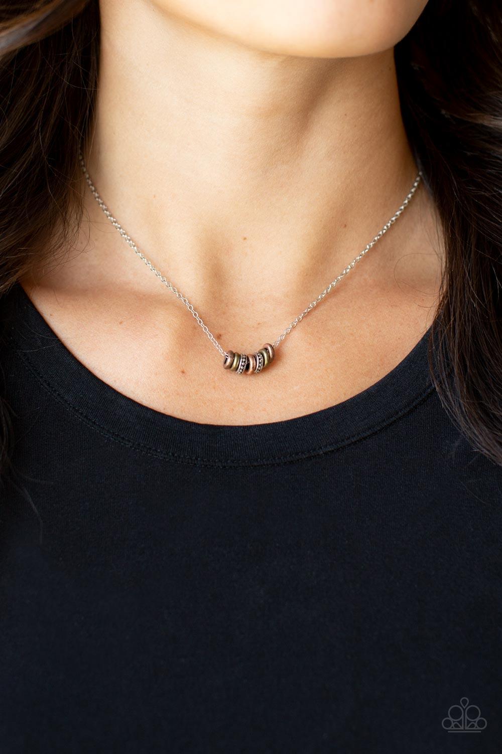 Paparazzi Accessories Dainty Dalliance - Multi An antiqued collection of smooth brass and copper rings and studded silver rings glide along a dainty silver chain below the collar, creating a minimalist inspired look. Features an adjustable clasp closure.