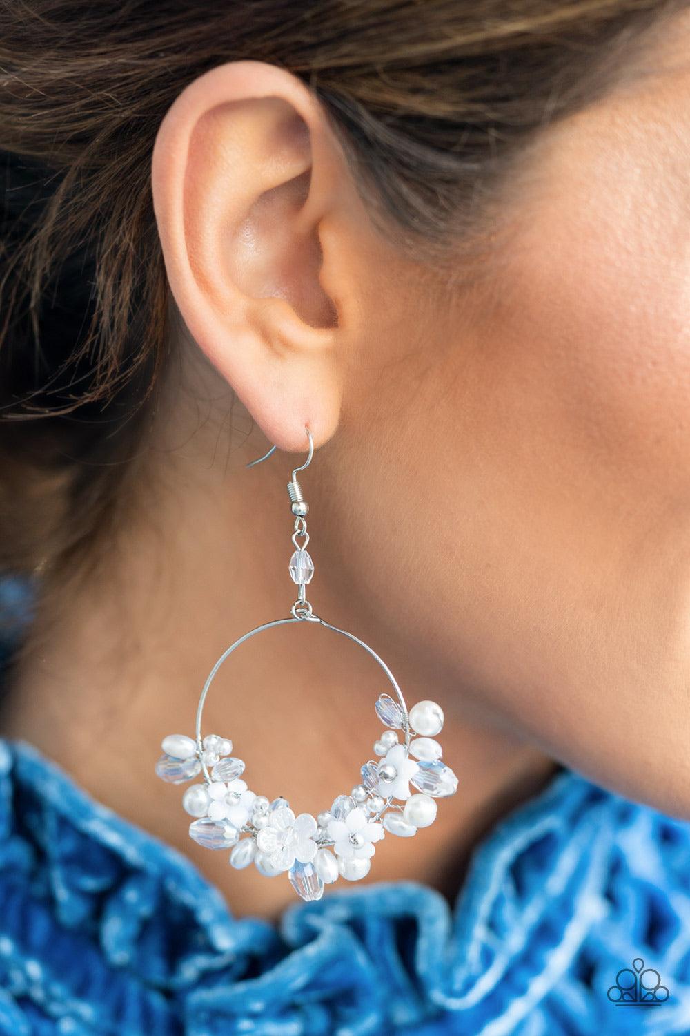 Paparazzi Accessories Floating Gardens - White A timeless collection of iridescent crystal-like accents, dainty white pearls, and white floral frames delicately cluster along the bottom of a silver hoop, creating a glamorous glow. Earring attaches to a st