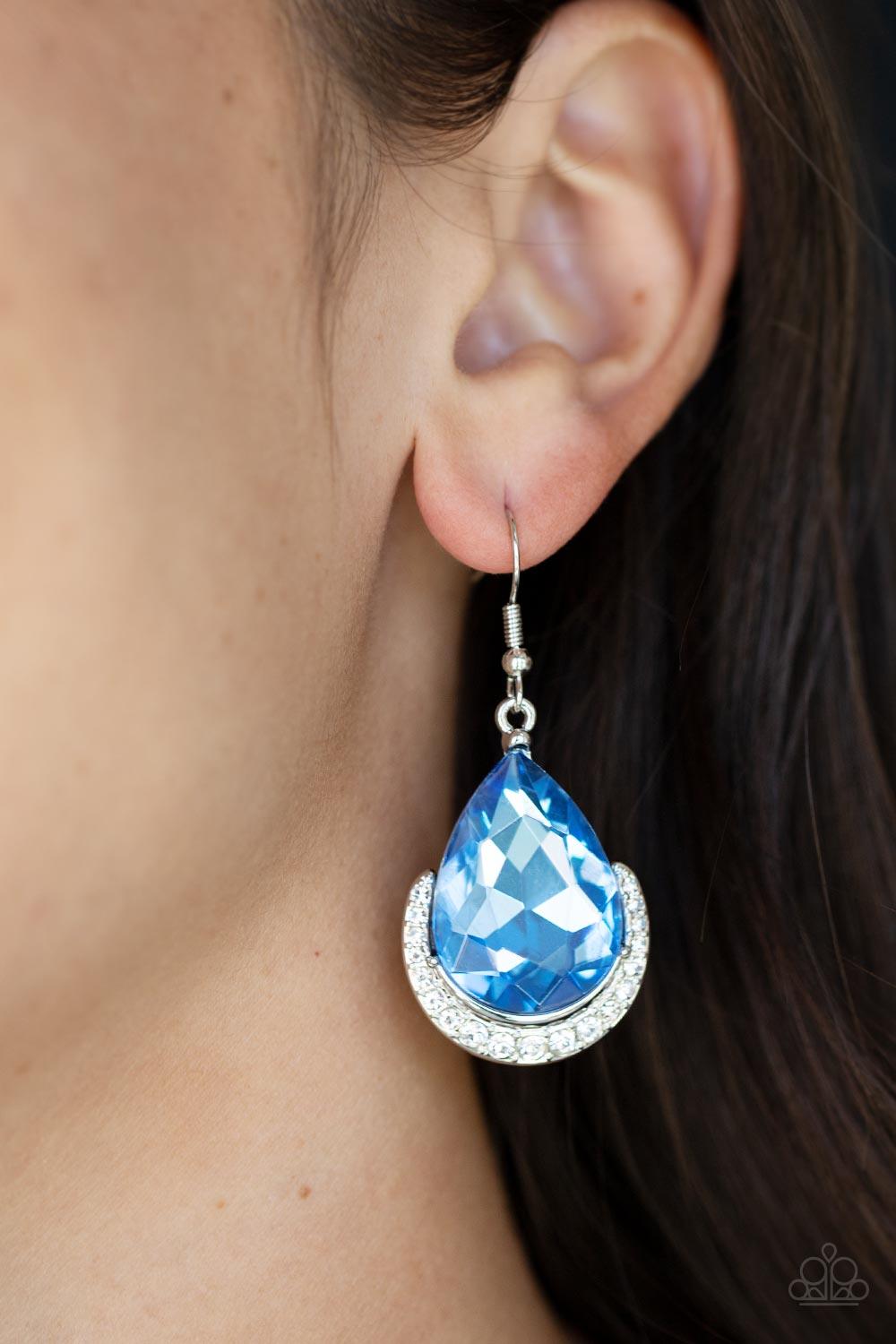 Paparazzi Accessories Mega Marvelous - Blue Dotted in white rhinestones, a dainty silver bar curves around the bottom of a dramatically oversized blue teardrop rhinestone for a glamorous fashion. Earring attaches to a standard fishhook fitting. Sold as on