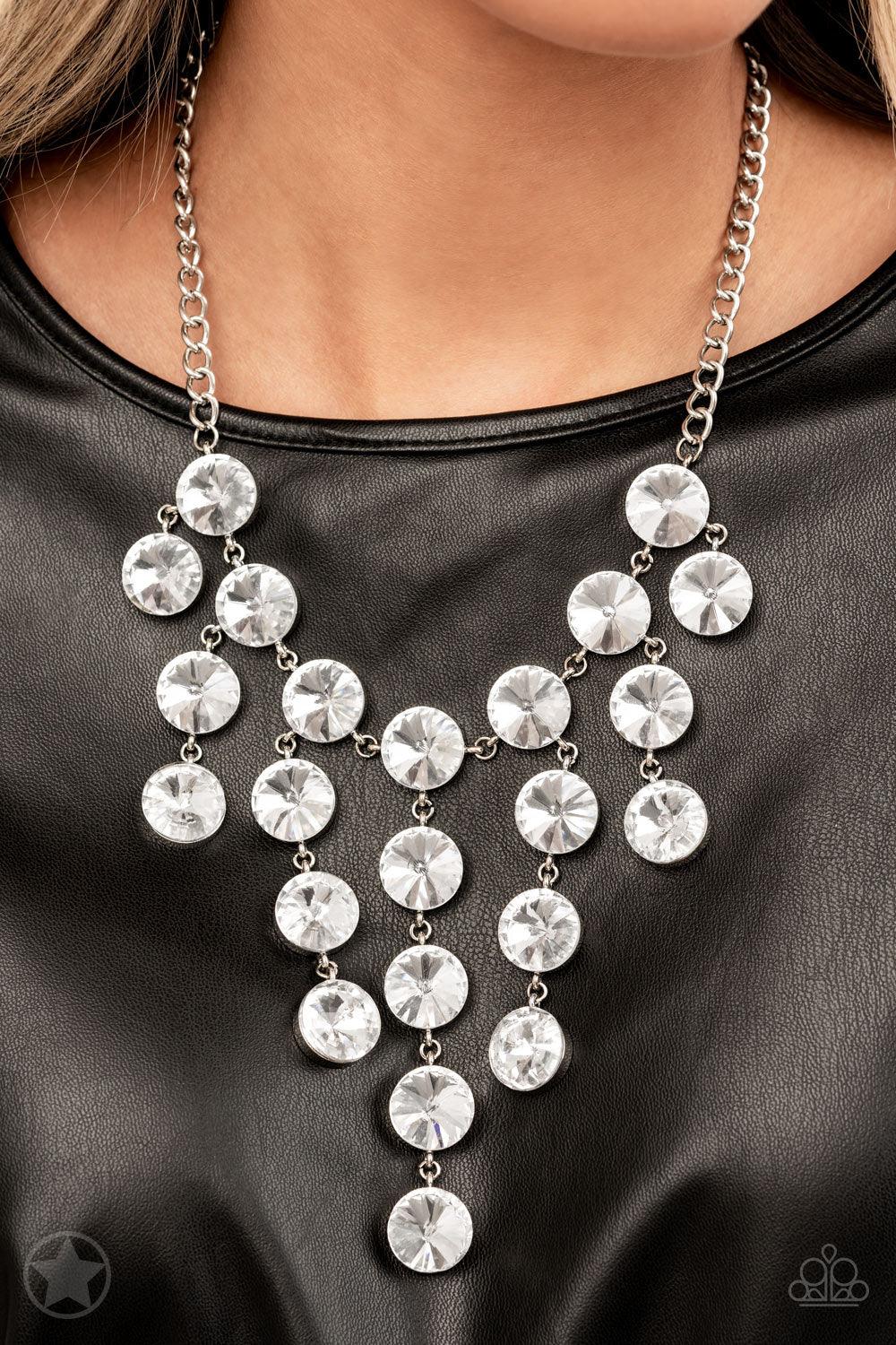 Paparazzi Accessories Spotlight Stunner - White Encased in sleek silver fittings, dramatically oversized white rhinestones delicately link into twinkly tassels that taper off into a jaw-dropping fringe below the collar. Features an adjustable clasp closur