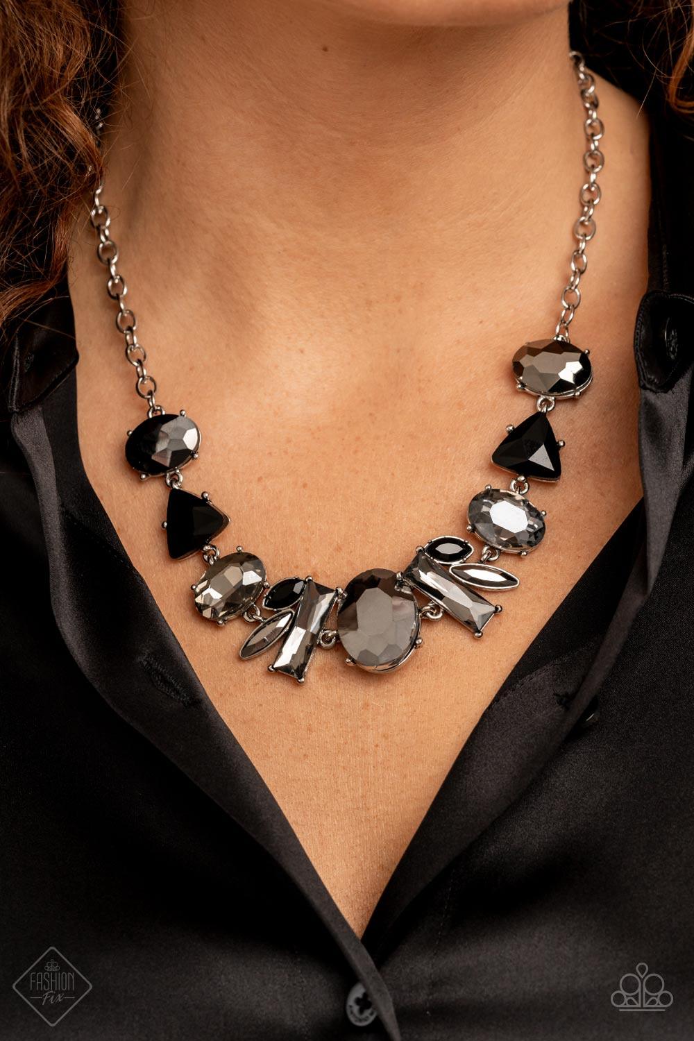 Paparazzi Accessories Modern Day Marvel - Silver Anchored by a glassy oval hematite gem, a mismatched collection of lustrous hematite, smoky, and black rhinestones in various modern shapes and sizes link together across the collar. The gritty display give