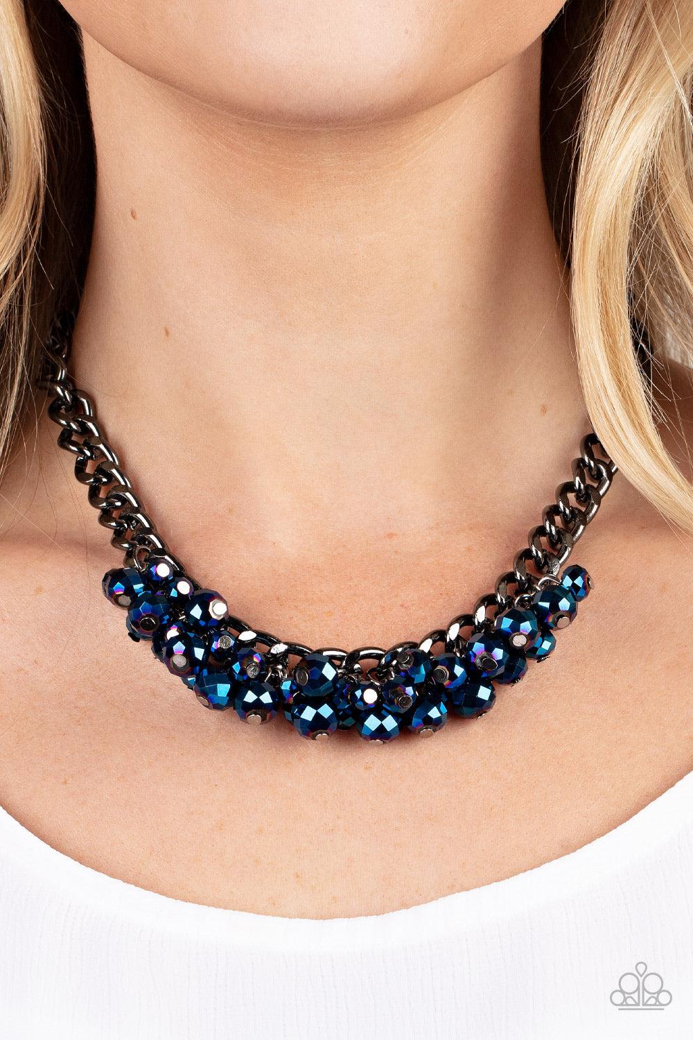 Paparazzi Accessories Galactic Knockout - Blue A faceted collection of metallic flecked blue beads cluster along the center of a chunky gunmetal curb chain, creating a stellar fringe below the collar. Features an adjustable clasp closure. Sold as one indi