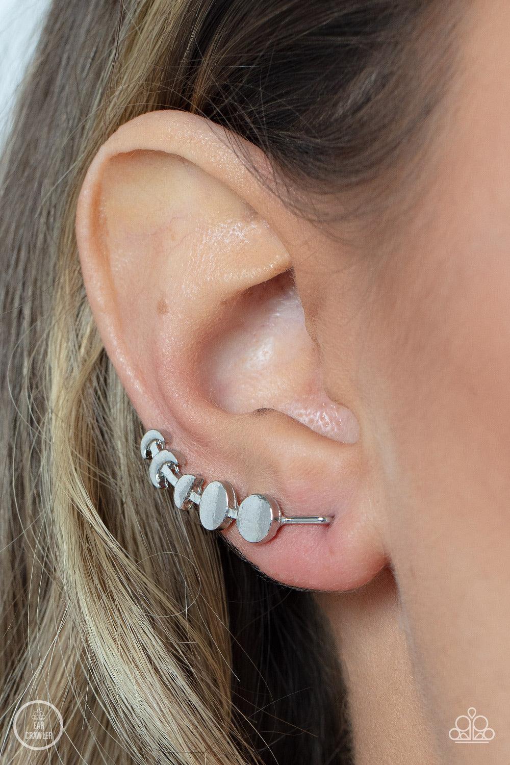 Paparazzi Accessories Its Just a Phase - Silver A dainty silver bar displays the phases of the moon as it curls across the ear for a stellar look. Features an extended post fitting that climbs the back of the ear and can be pressed together for a more sec