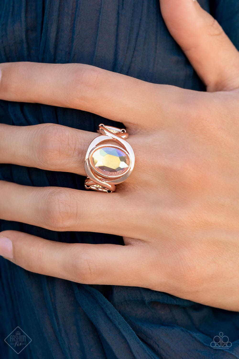 Paparazzi Accessories Mystical Treasure - Rose Gold Interwoven rose gold bars delicately encircle an iridescent Pale Rosette gem, creating a mystical centerpiece atop the finger. Features a stretchy band for a flexible fit. Sold as one individual ring. Ri