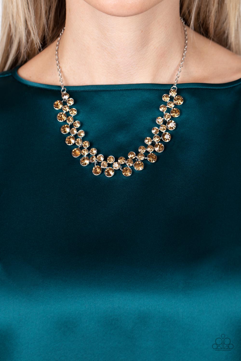 Paparazzi Accessories Won The Lottery - Brown Encased in sleek silver frames, staggered rows of bubbly golden topaz rhinestones effervescently link below the collar for a glamorous pop of sparkle. Features an adjustable clasp closure. Sold as one individu