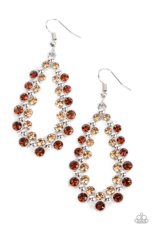 Paparazzi Accessories Its About to GLOW Down - Brown A glitzy collection of classic topaz and golden topaz rhinestones flank a studded silver teardrop frame, resulting in a glamorous lure. Earring attaches to a standard fishhook fitting. Sold as one pair