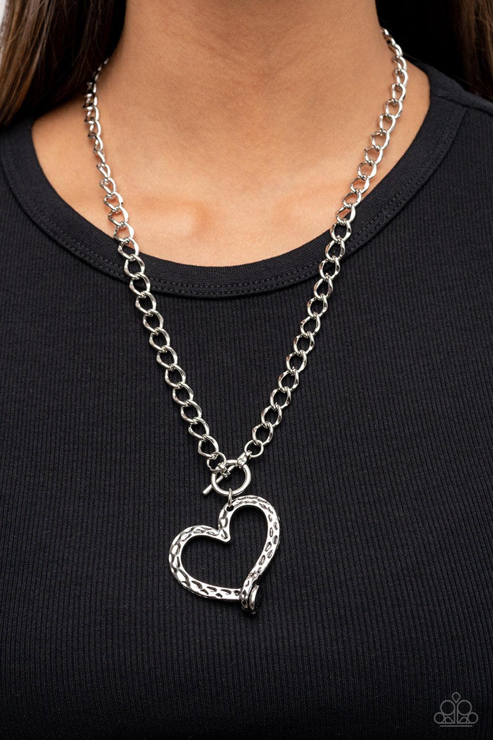 Paparazzi Accessories Reimagined Romance - Silver A hammered silver heart frame gently twists from a toggle closure at the bottom of a chunky silver chain, resulting in a romantically rustic pendant. Features a toggle closure. Sold as one individual neckl