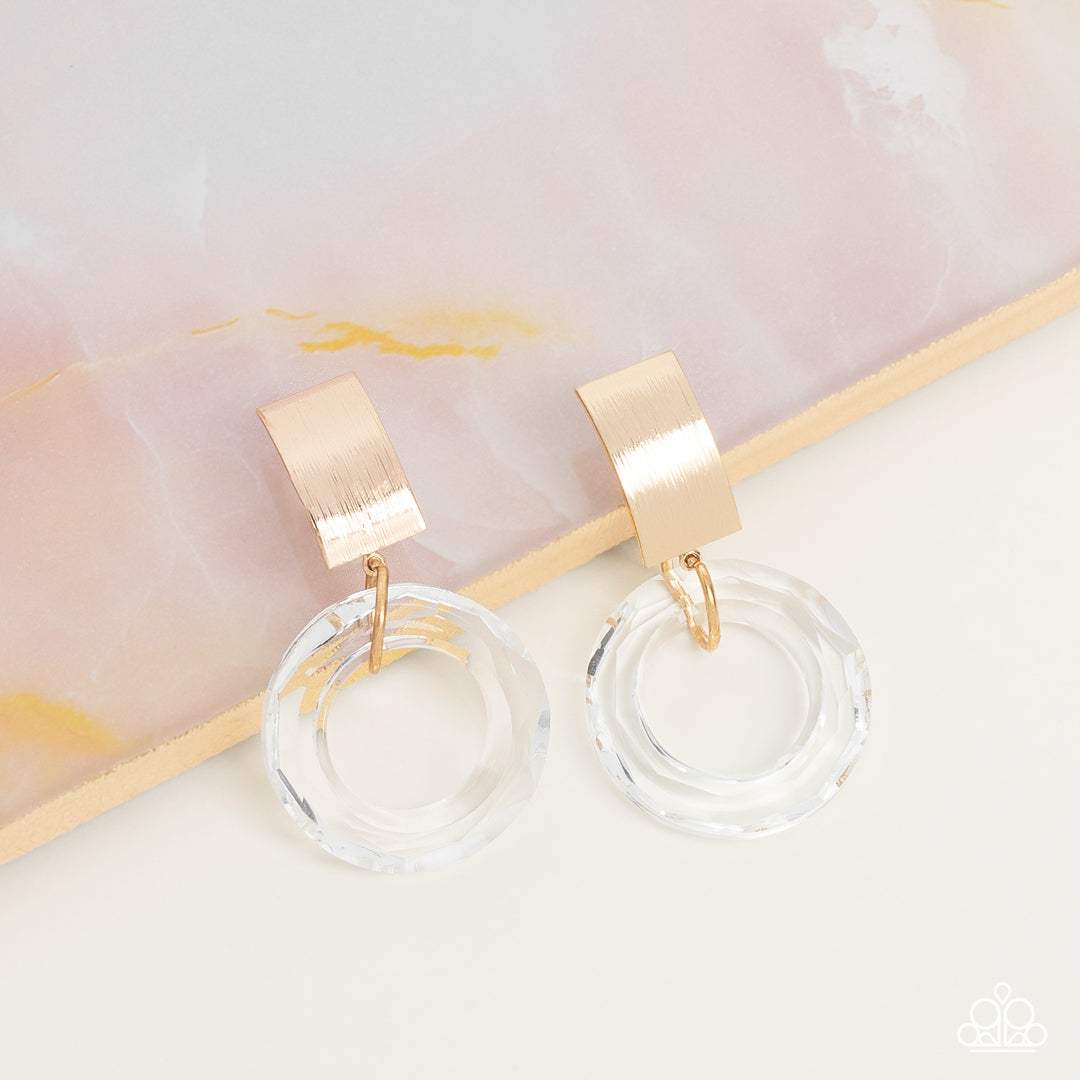 Paparazzi Accessories Clear Out! - Gold *Clip-On A faceted acrylic ring links to the bottom of a curved gold plate, creating a modern lure. Earring attaches to a standard clip-on fitting. Sold as one pair of clip-on earrings. Jewelry
