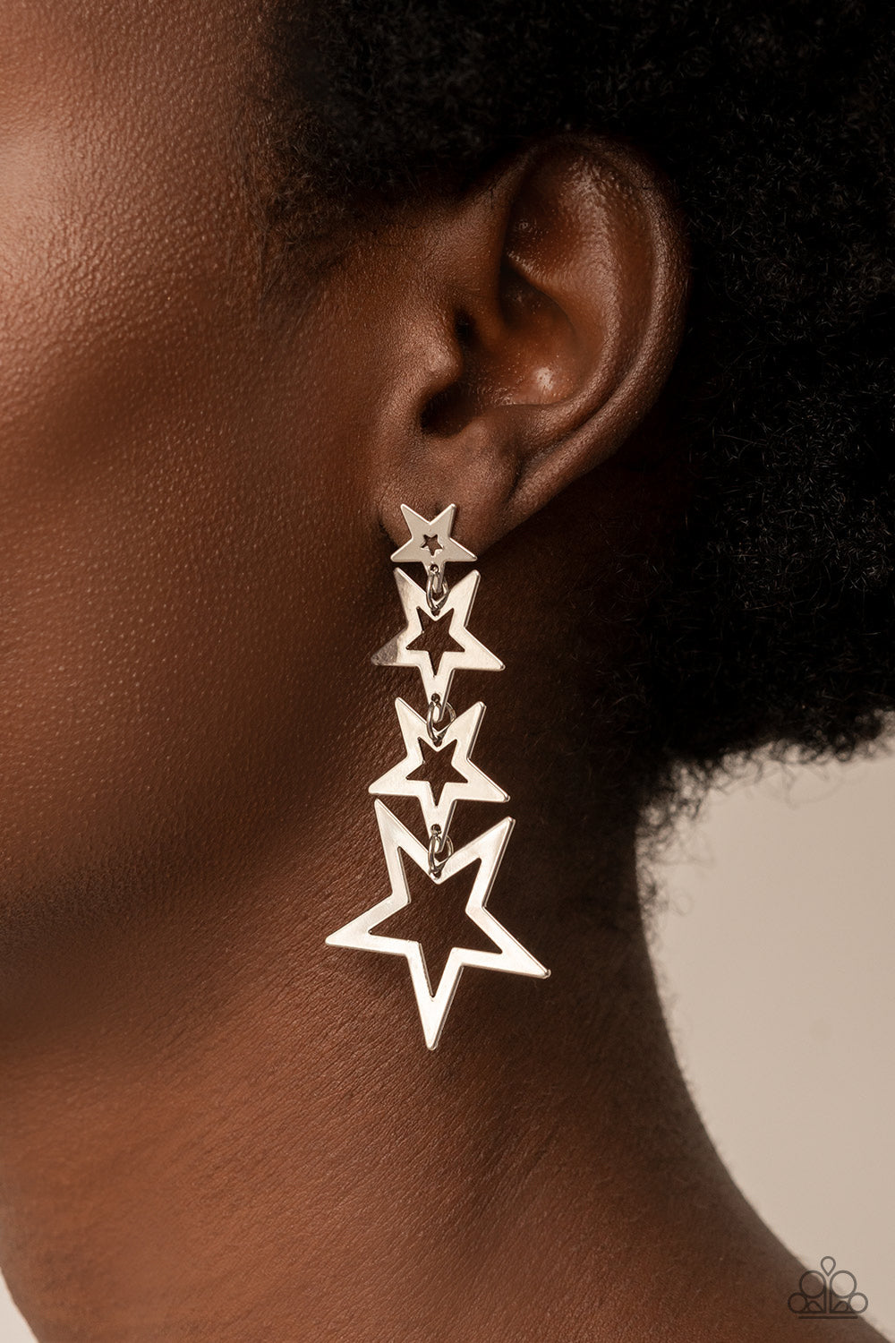 Paparazzi Accessories Superstar Crescendo - Silver Flat silver star frames gradually increase in size as they delicately link into a stellar tassel, resulting in an out-of-this-world fashion. Earring attaches to a standard post fitting. Sold as one pair o