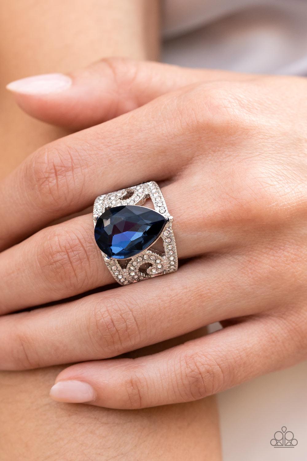 Paparazzi Accessories Kinda a Big Deal - Blue An oversized teardrop gem in the Pantone® of Polar Night embellishes the center of a regal, filigree-filled band dotted in glassy white rhinestones, invoking a royal radiance atop the finger. Features a stretc