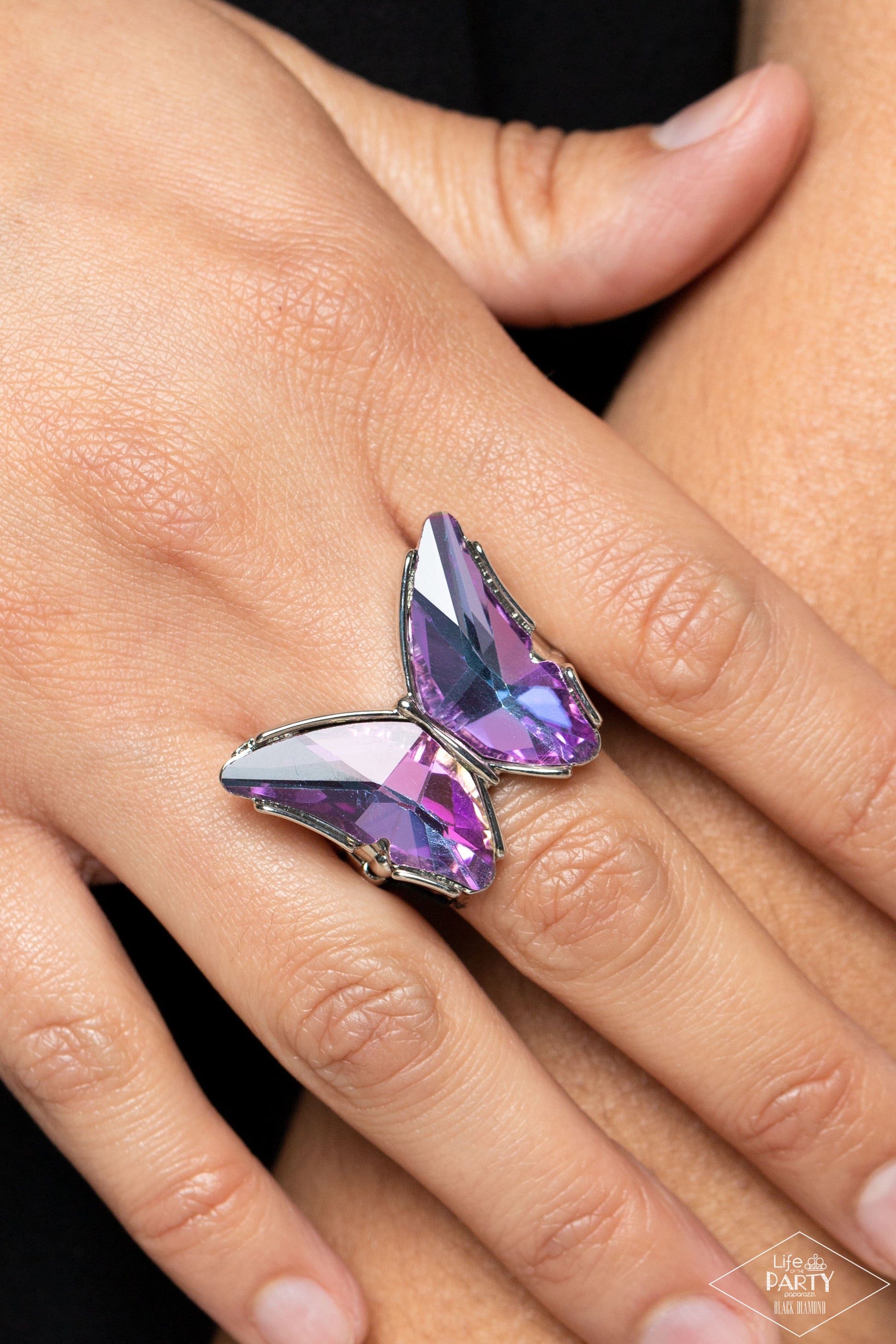 Paparazzi Accessories Fluorescent Flutter - Purple Featuring a stellar UV finish, a pair of glittery purple gems adorns the wings of a silver butterfly atop the finger for an eye-catching finish. Features a stretchy band for a flexible fit. Due to its pri