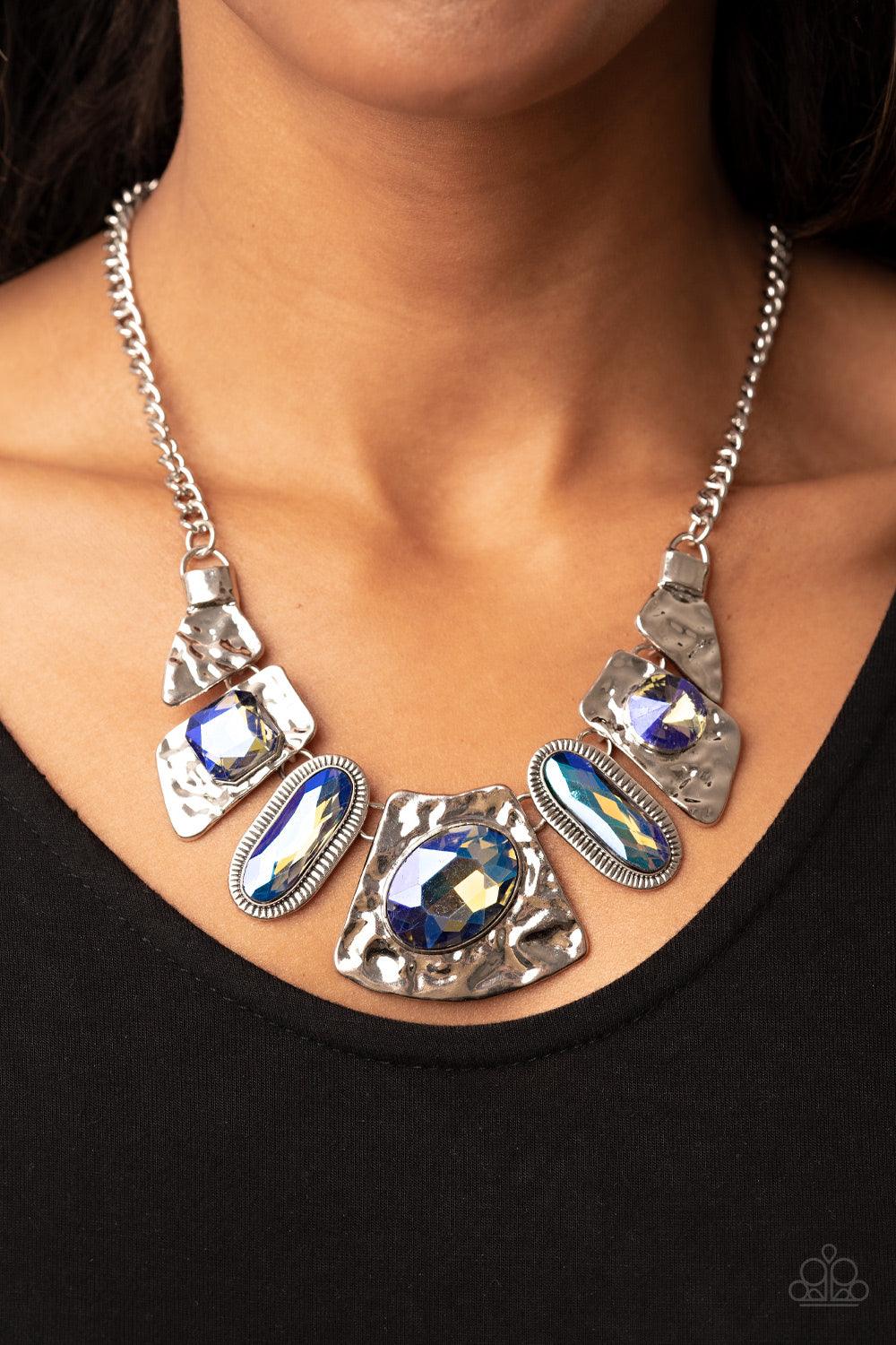 Paparazzi Accessories Futuristic Fashionista - Multi Featuring a stellar UV shimmer, mismatched iridescent multicolored gems adorn the front of hammered silver plates that abstractly connect below the collar for an out-of-this-world sparkle. Features an a