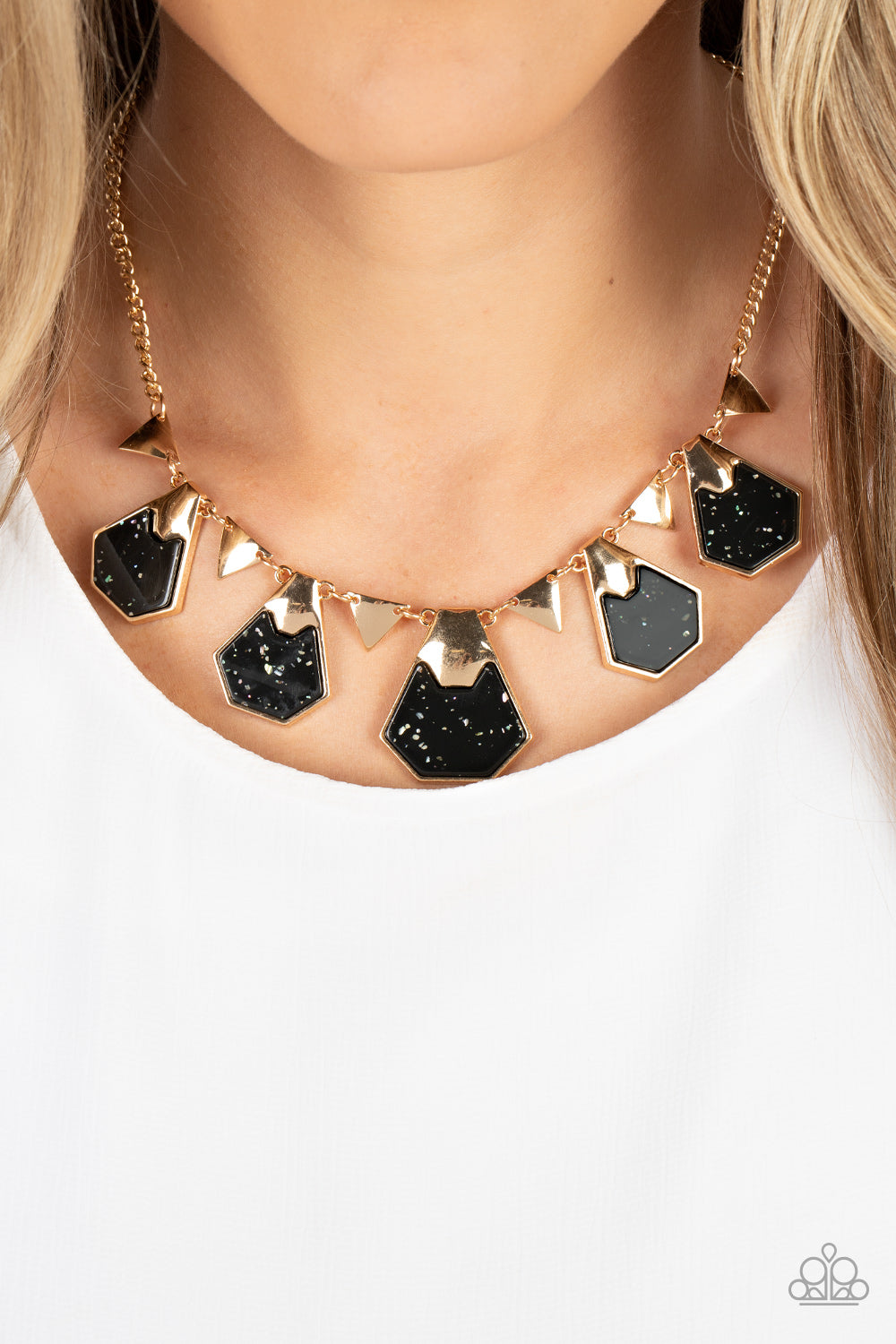Paparazzi Accessories Extra Exclusive - Black Flecked in iridescent shell-like accents, geometric black acrylic frames are pinched in placed by folds of gold atop the front of flat gold frames. The glimmering frames alternate with dainty gold triangular f