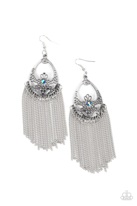 Paparazzi Accessories Castle Cottage - Blue An antiqued curtain of silver chains streams from the bottom of an airy stenciled silver oval frame. An iridescent blue rhinestone adorns the center of the whimsical frame, adding a mystical pop of color to the