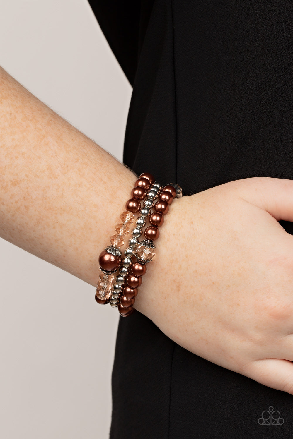 Paparazzi Accessories Positively Polished - Brown Stretchy brown pearl and silver beaded bracelets are adorned with ornate silver accents and golden crystal-like beads, creating polished layers around the wrist. Sold as one set of three bracelets. Bracele