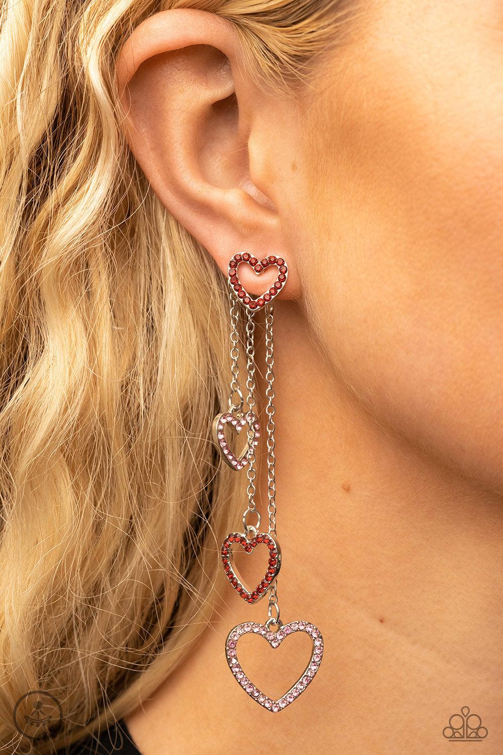 Paparazzi Accessories Falling In Love - Multi Encrusted in dainty red rhinestones, a glittery silver heart fitting attaches to a double-sided post designed to fasten behind the ear. Attached to dainty silver chains of varying lengths, a glittery collectio