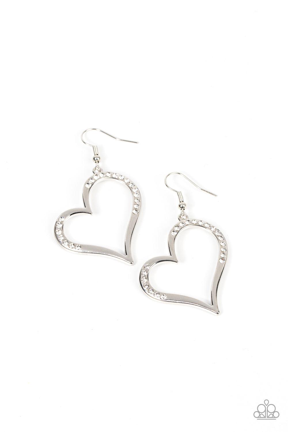 Paparazzi Accessories Tenderhearted Twinkle - White A curvaceous silver heart is encrusted in sections of glassy white rhinestones, invoking a flirtatious flair. Earring attaches to a standard fishhook fitting. Sold as one pair of earrings. Earrings