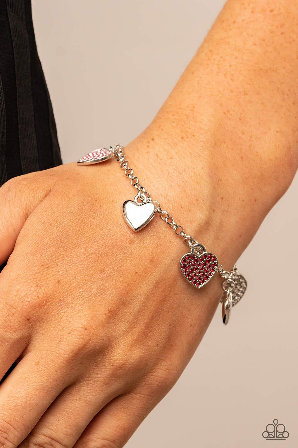 Paparazzi Accessories Lusty Lockets - Multi Shiny silver heart charms delicately alternate with white, red, and pink rhinestone encrusted heart frames along a silver chain around the wrist, resulting in a flirtatious fringe. Features an adjustable clasp c