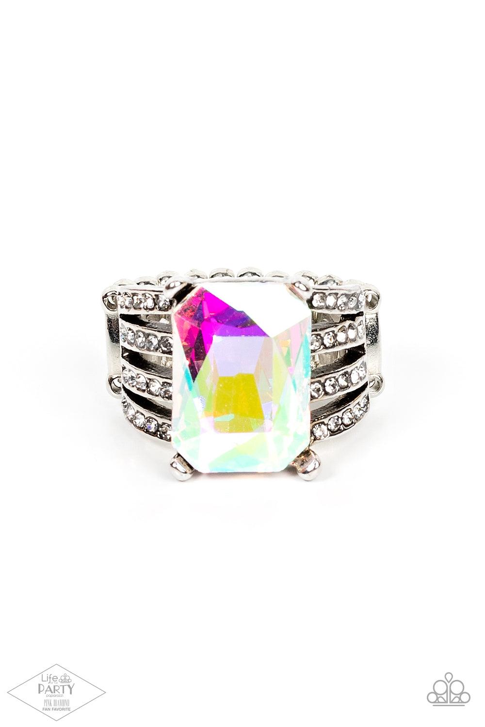 Paparazzi Accessories Expect Heavy REIGN - Multi Featuring a regal emerald style cut, an oversized iridescent gem is pressed into the center of stacked silver bands radiating with dainty white rhinestones for a dramatic look. Features a stretchy band for