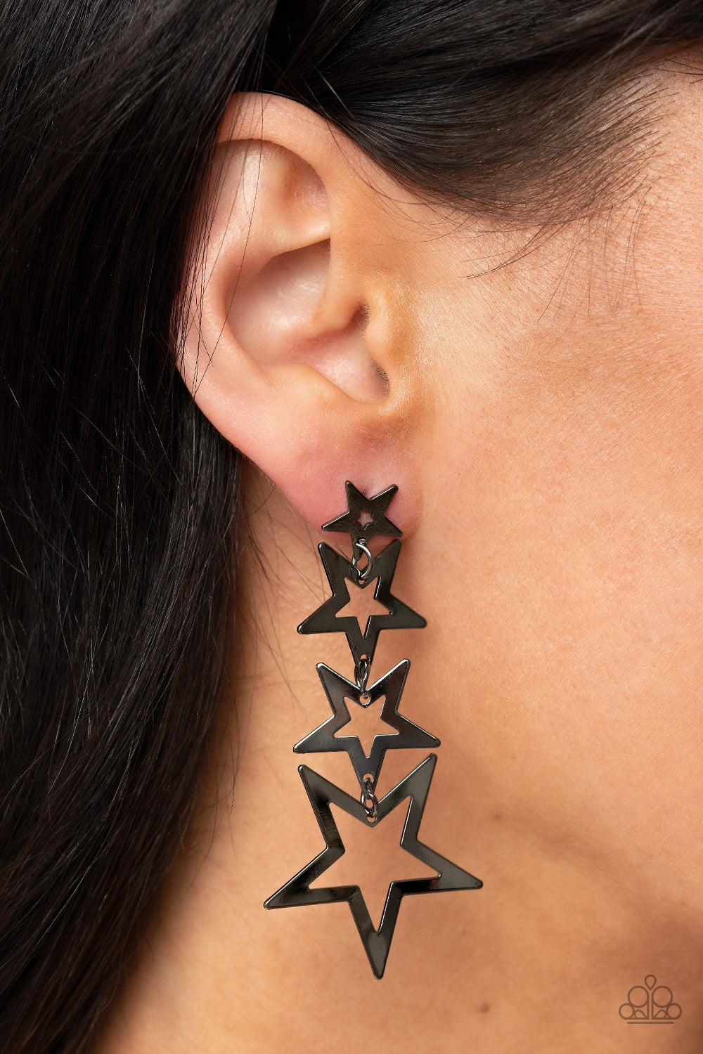 Paparazzi Accessories Superstar Crescendo - Black Flat gunmetal star frames gradually increase in size as they delicately link into a stellar tassel, resulting in an out-of-this-world fashion. Earring attaches to a standard post fitting. Sold as one pair