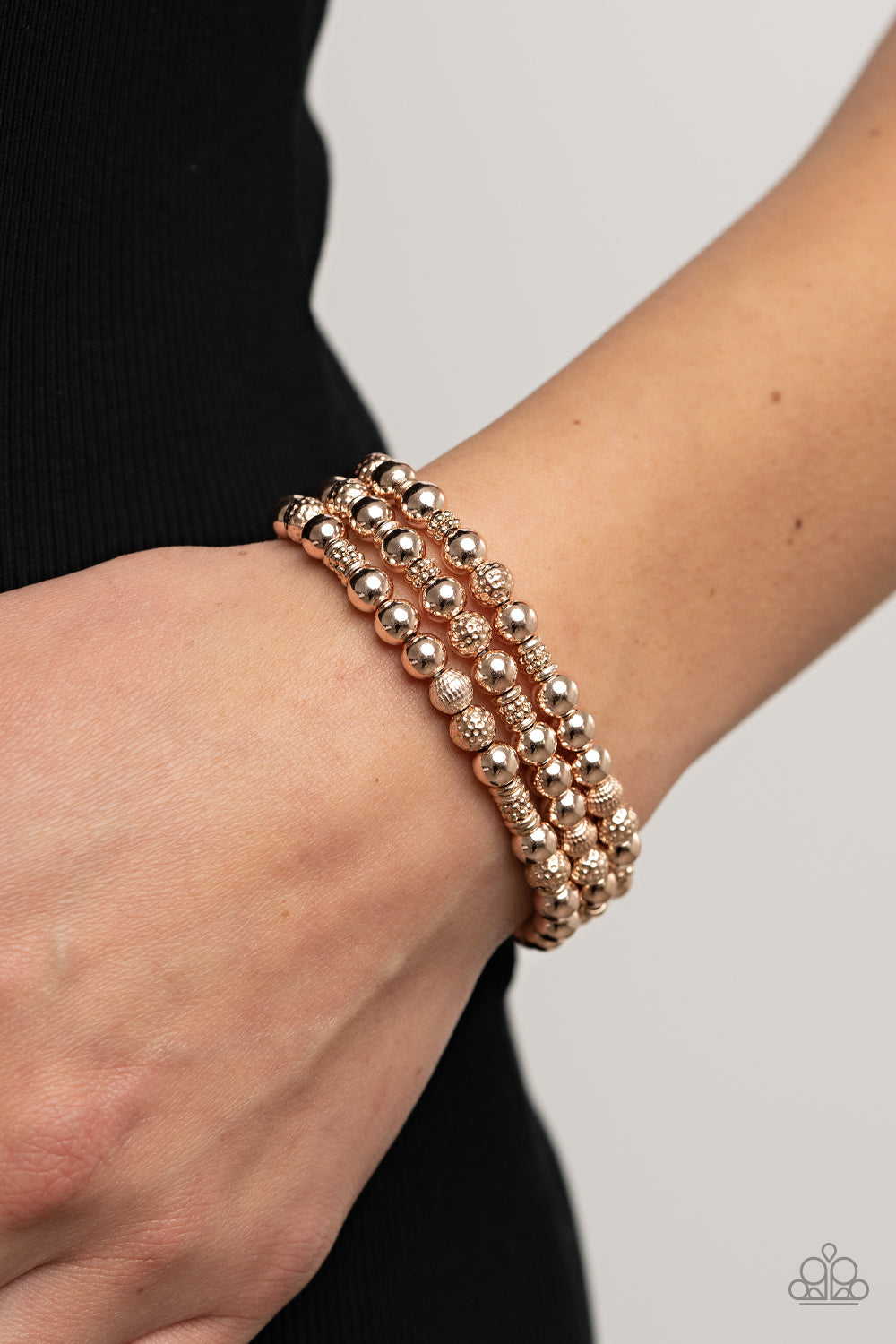 Paparazzi Accessories Boundless Boundaries - Rose Gold A shiny collection of smooth, studded, and textured rose gold beads are threaded along stretchy bands around the wrist, creating dainty layers. Sold as one set of three bracelets. Jewelry