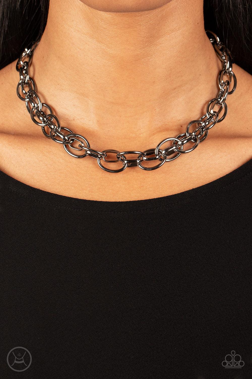 Paparazzi Accessories Tough Crowd - Black An oversized gunmetal chain interlocks with an oval linked chain, resulting in a rebellious fashion around the neck. Features an adjustable clasp closure. Sold as one individual choker necklace. Includes one pair
