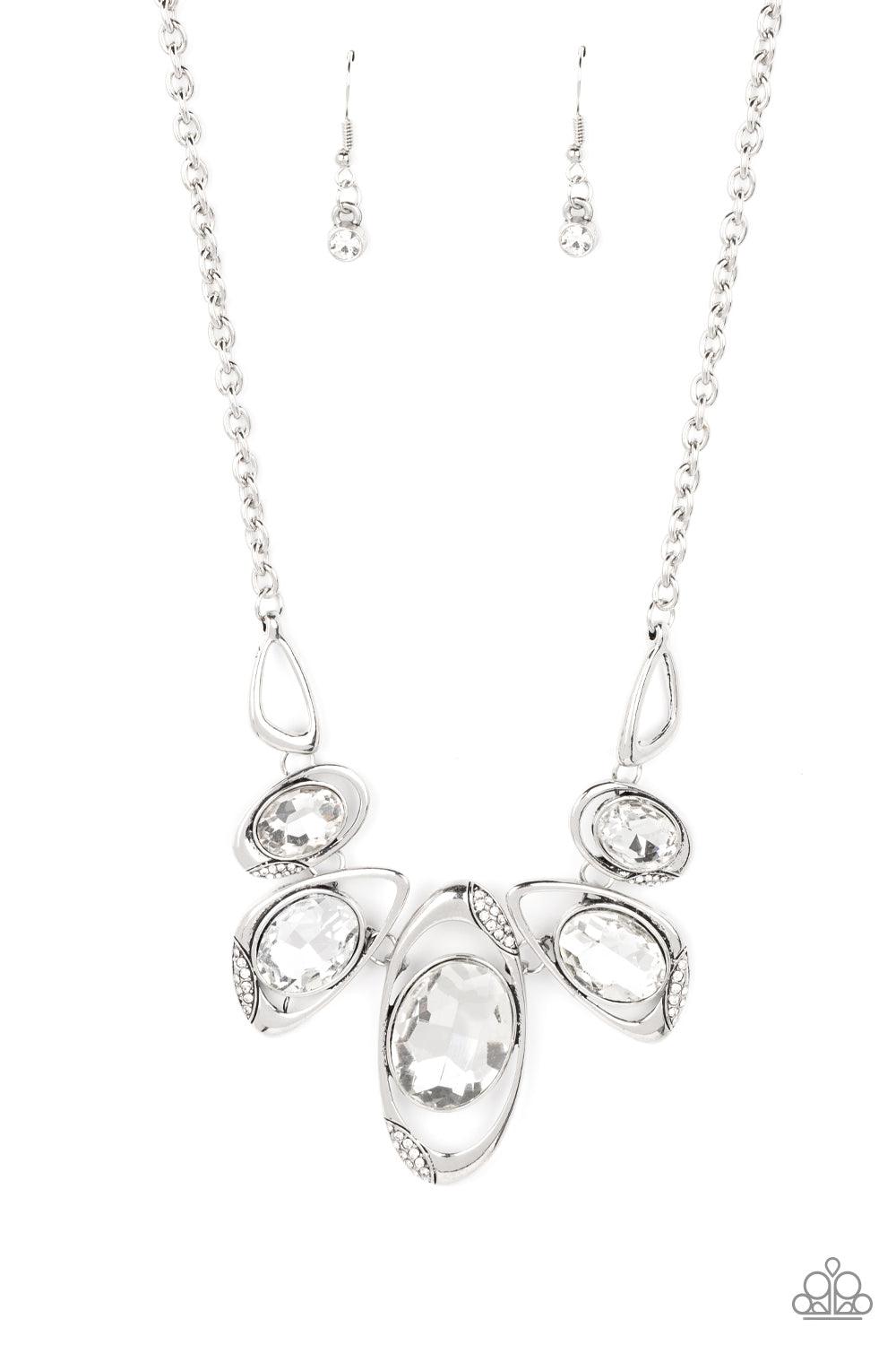 Paparazzi Accessories Hypnotic Twinkle - White Dusted in sections of glassy white rhinestones, asymmetrical silver frames curl around oversized white gems below the collar. Varying in shape, the mismatched frames increase in size as they near the center f