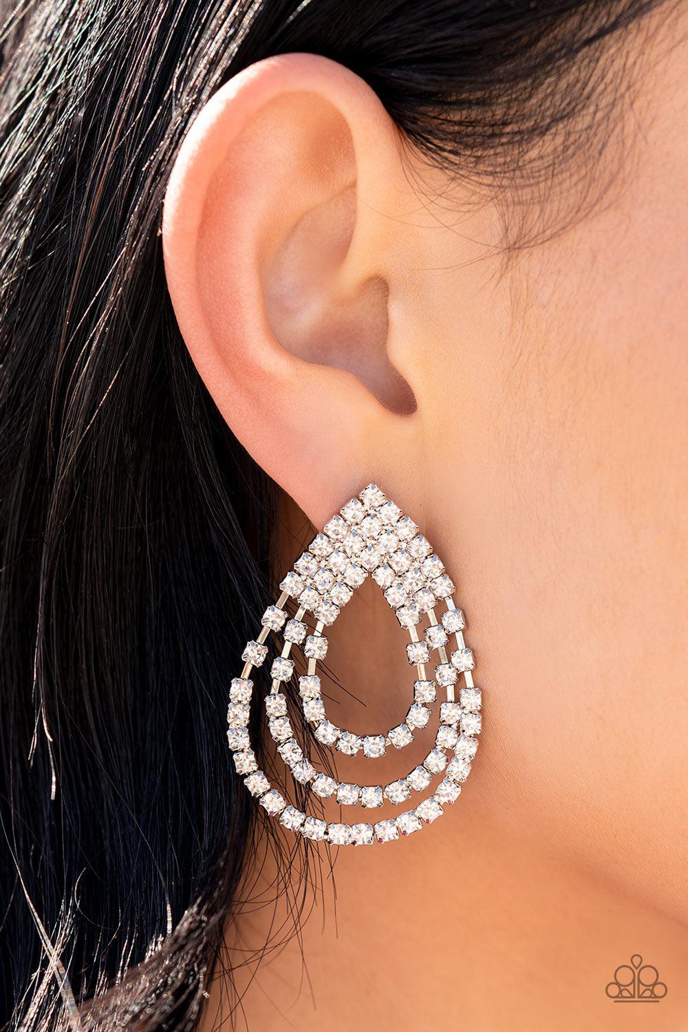 Paparazzi Accessories Take a POWER Stance - White Loops of glassy white rhinestones ripple out from the bottom of a stationary triangular fitting that is dotted in glittery white rhinestones, resulting in a timeless teardrop chandelier. Earring attaches t